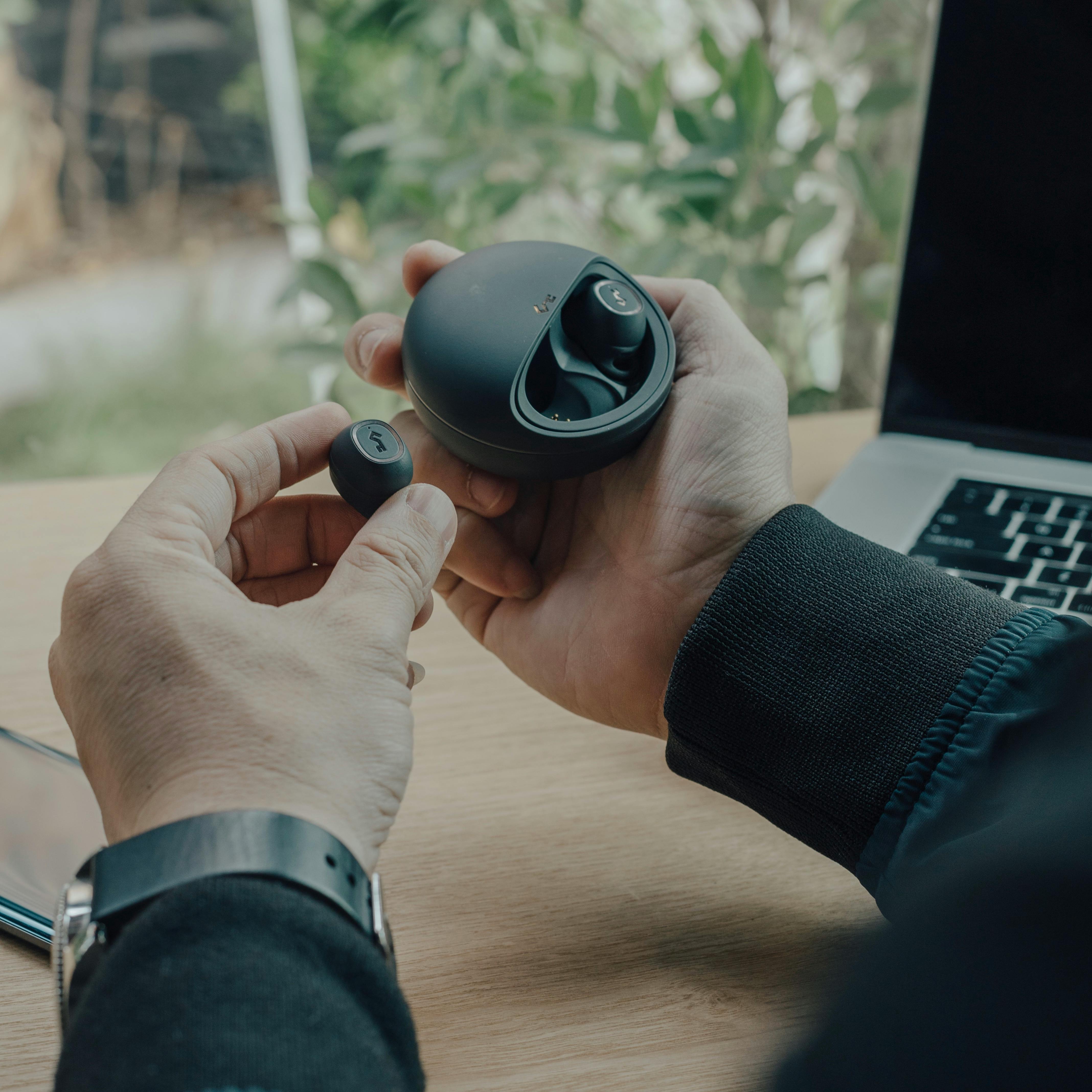 Power bank portátil cargando smartphone y smartwatch junto a bolsa de pádel