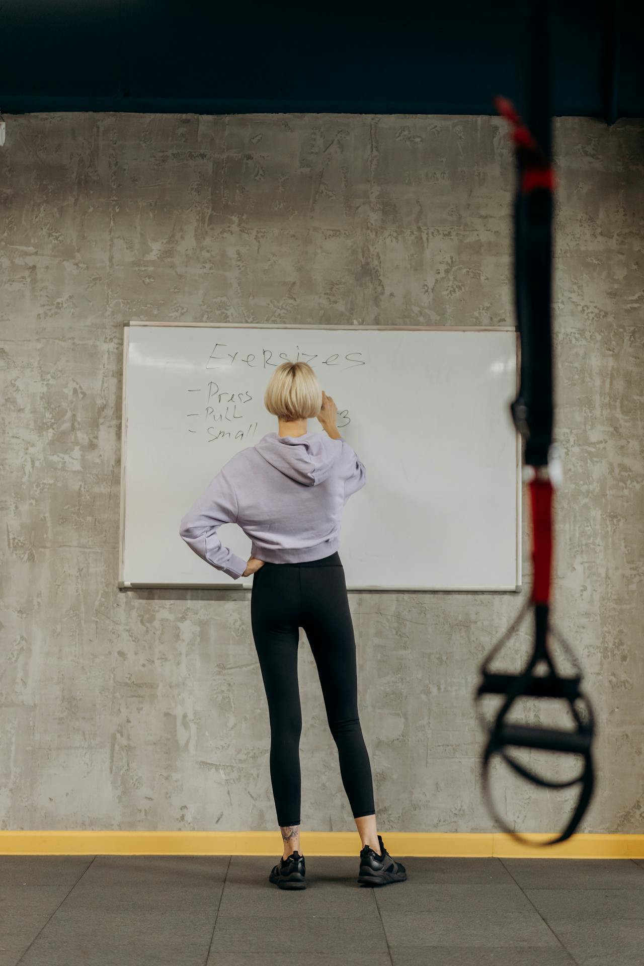 Atleta con cuaderno planificando rutina de entrenamiento y prevención, momento de organización deportiva con bolsa de pádel visible