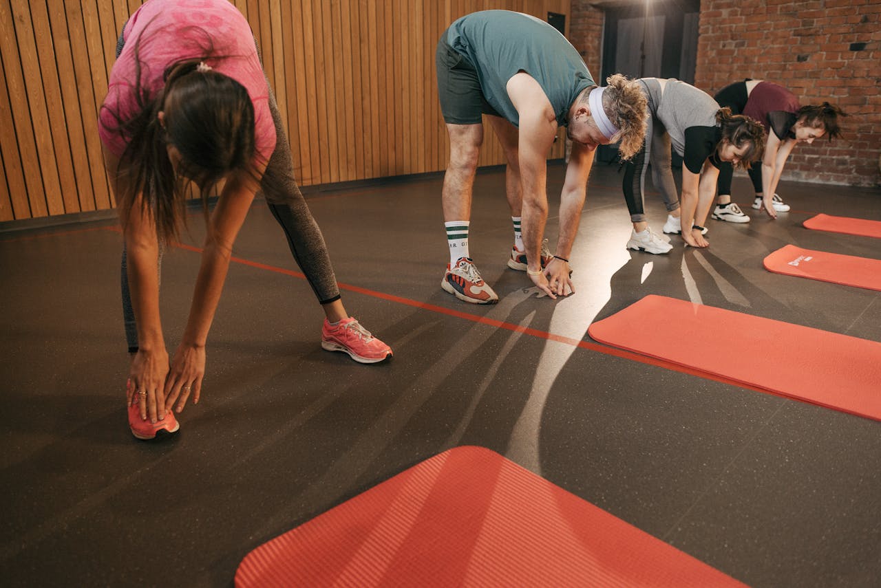 Grupo de jugadores de pádel realizando ejercicios de calentamiento juntos antes del partido, sesión de preparación en equipo